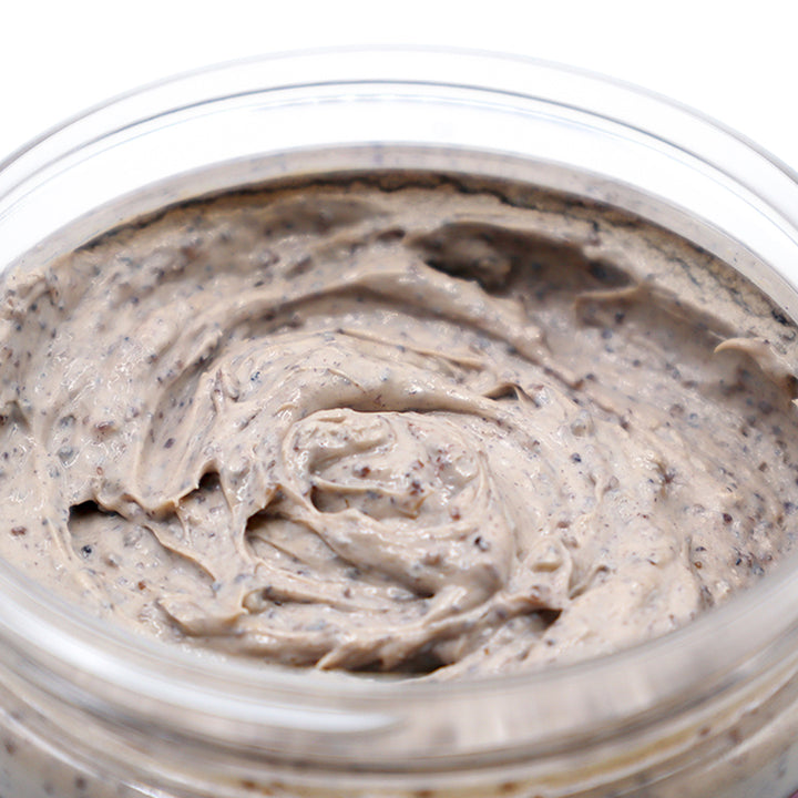 Close-up of a jar filled with a creamy, light brown Lavender &amp; Walnut Soap Scrub